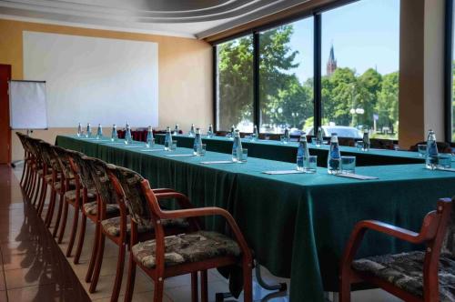 a long table with a green table cloth and chairs at Hotel Gołębiewski Białystok in Białystok