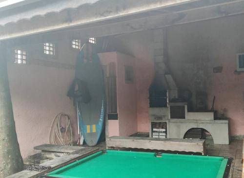 a swimming pool with a surfboard in a room at Casa de hóspedes Caraguatatuba in Caraguatatuba