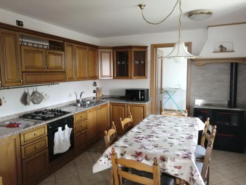 a kitchen with wooden cabinets and a table with a table cloth at Nadia Haus in Luserna