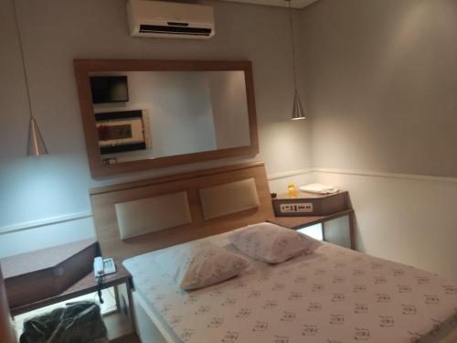 a bedroom with a bed and a large mirror at Hotel Nova Lisboa - Adult Only- in Sao Paulo