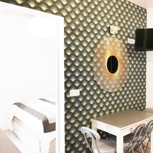 - une chambre dotée d'un mur avec un miroir et une table dans l'établissement Home in Paris Orsay - Grenelle Romantic Flat, à Paris