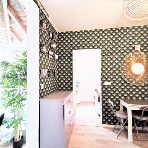 une salle avec une table et une salle à manger avec un mur recouvert de rampes dans l'établissement Home in Paris Orsay - Grenelle Romantic Flat, à Paris
