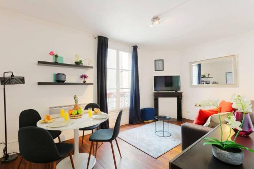 a living room with a table and chairs at Central Paris & Bastille - CityApartmentStay in Paris