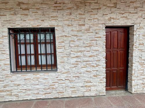 La Casa de Agos في لا ريوخا: مبنى من الطوب مع نافذتين وباب احمر