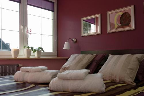 una pila de almohadas en una cama en una habitación en Ferienwohnung in der Kaschubei, in ruhiger Lage am Waldrand, in der Nähe von Danzig und Sopot, en Sulmin
