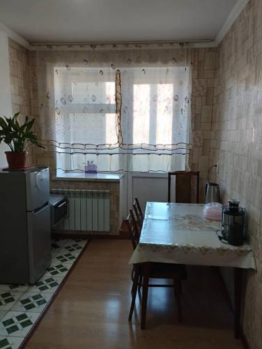een keuken met een tafel met stoelen en een raam bij Muras in Naryn