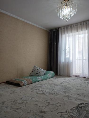 een slaapkamer met een bed in een kamer met een kroonluchter bij Muras in Naryn