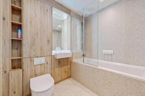 a bathroom with a toilet and a sink and a tub at 1Bed apt in Whitechapel with a balcony & near tube in London