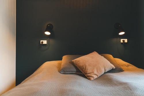 a bedroom with a bed with two lights on the wall at Danhostel Aarhus City in Aarhus