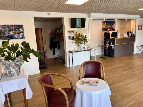 a room with two tables and chairs and a woman in a salon at Logis Hôtel Restaurant Du Lion D'argent Et Des Tanneries in La Châtre