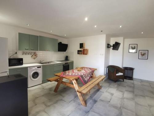 un salon avec une table et une cuisine dans l'établissement Les Bruyères cottage, à La Bazoque