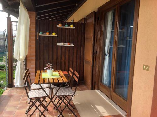 Una mesa y sillas de madera en un patio. en Casa Zaza', en Premariacco