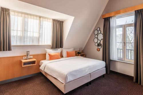 a hotel room with a bed and a window at Hotel Aalsmeer in Aalsmeer