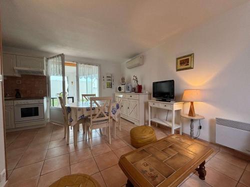 un salon avec une table et une cuisine dans l'établissement Maison climatisée avec jardin, proche plage et commerces, animaux acceptés - FR-1-494-40, à Vaux-sur-Mer