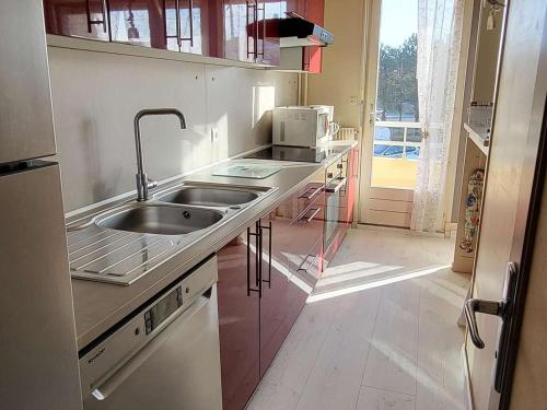 une petite cuisine avec un évier et un réfrigérateur dans l'établissement Appartement 50m² avec Balcon, Parking Privé et Wifi à Deux Pas de la Plage - FR-1-674-36, à Berck-sur-Mer