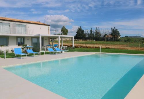 uma piscina com cadeiras azuis e uma casa em Ferienhaus in Partinico mit Privatem Pool em Balestrate