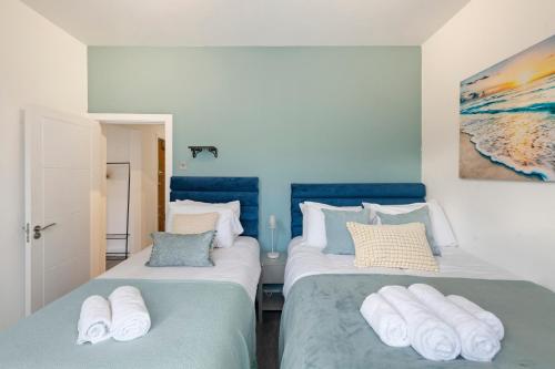 dwa łóżka w pokoju niebiesko-białym w obiekcie Rose Suite Camden Town 3 Bedroom Sleeps 11 w Londynie