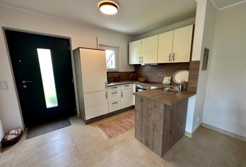 eine Küche mit einem Waschbecken und einer schwarzen Tür in der Unterkunft Ferienwohnung IDA in Peiting