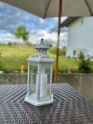 a lantern sitting on top of a table with an umbrella at Ferienwohnung IDA in Peiting
