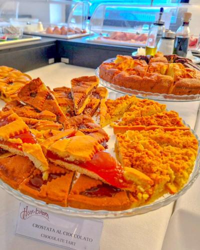 a display of different types of cakes and pies at Hotel Europa in Taranto