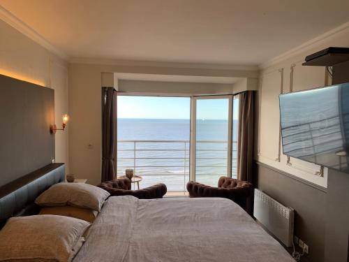 een slaapkamer met 2 bedden en uitzicht op de oceaan bij C-view Holiday in Middelkerke
