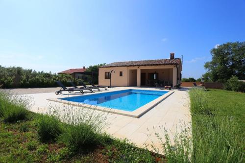 a villa with a swimming pool in front of a house at Ferienhaus mit Privatpool für 5 Personen ca 80 qm in Loborika, Istrien Südküste von Istrien - b57678 in Loborika