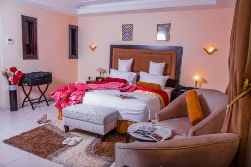 a bedroom with a bed and a couch and a chair at LIMEWOOD HOTEL in Port Harcourt