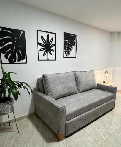 een bank in een woonkamer met foto's aan de muur bij CASA BONITA SALENTO - Suite para parejas o Alojamiento en Grupos in Salento