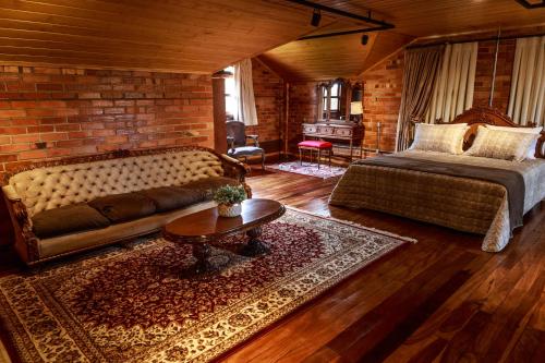 um quarto com uma cama, um sofá e uma mesa em Pousada Rugero em Nova Pádua