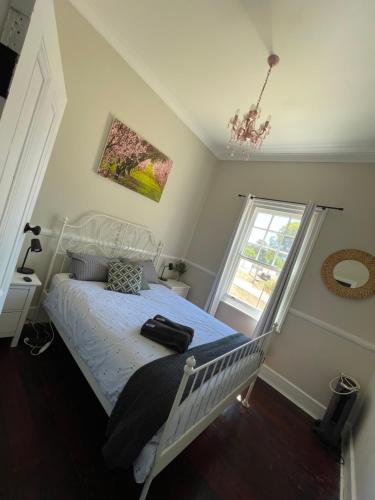 a bedroom with a white bed and a window at Bullock and Company Cottage in Toodyay