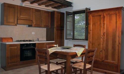 una cucina con tavolo, sedie e piano cottura di Wohnung auf der ersten Etage a Campiglia Marittima
