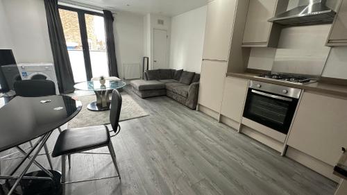 uma cozinha e sala de estar com um sofá e uma mesa em 1 bedroom Flat in Elephant and castle zone 1 London em Londres