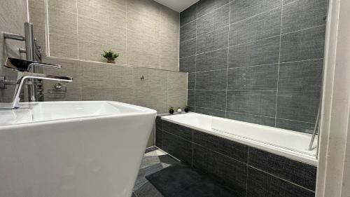 uma casa de banho com uma banheira branca e um lavatório. em 1 bedroom Flat in Elephant and castle zone 1 London em Londres