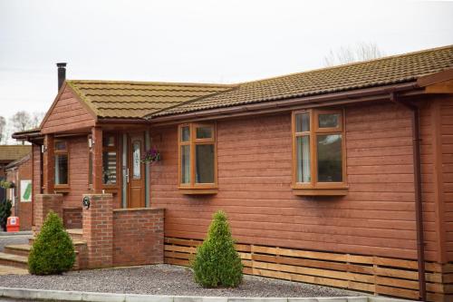 a small wooden house withwindows at 3 Bedroom lodge with hot tub in York