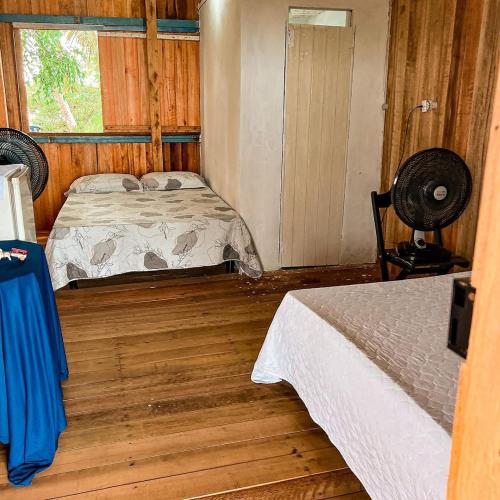 um pequeno quarto com uma cama e uma janela em Hostel Capitão da Ilha em Maracanã