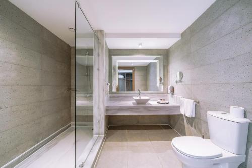 a bathroom with a shower and a toilet and a sink at Pickalbatros Vita Resort - Portofino Marsa Alam in Abu Dabab