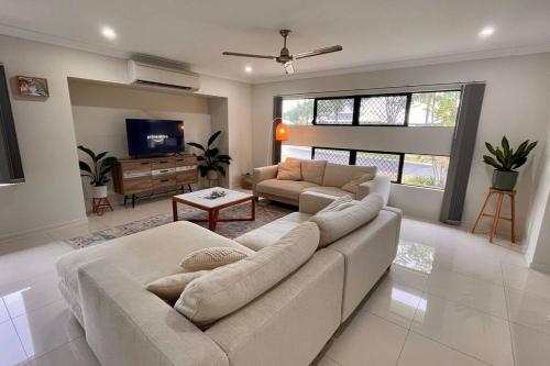 a living room with a couch and a tv at New Pool Now Open! - Trinity Beach Haven - Luxury 4 bedroom home, Steps to the Beach, Surrounded by Mountains in Trinity Beach