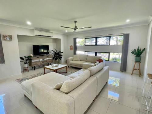 a living room with a couch and a tv at New Pool Now Open! - Trinity Beach Haven - Luxury 4 bedroom home, Steps to the Beach, Surrounded by Mountains in Trinity Beach
