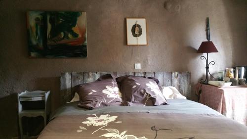 Schlafzimmer mit einem Bett mit lila und weißen Kissen in der Unterkunft L'AUBRIETE in Recoules-dʼAubrac