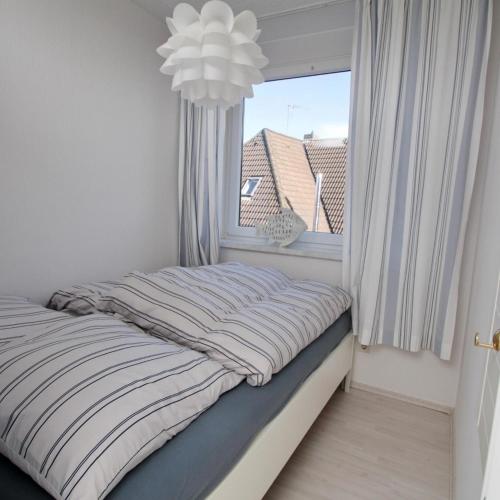 a bed in a room with a window at Schönes Appartement in Burhave in Butjadingen