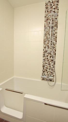 a white bathroom with a shower and a tub at Schönes Appartement in Burhave in Butjadingen