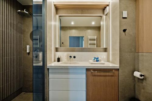 a bathroom with a sink and a mirror at Apartamenty Wydma & Las BlueApart in Jastarnia