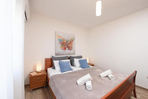 a bedroom with a large bed with blue pillows at Sunset Beach Suites in Kožino