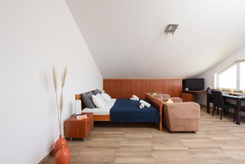 a bedroom with a bed and a desk and a chair at Sunset Beach Suites in Kožino