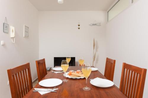 a wooden table with wine glasses and food on it at Sunset Beach Suites in Kožino