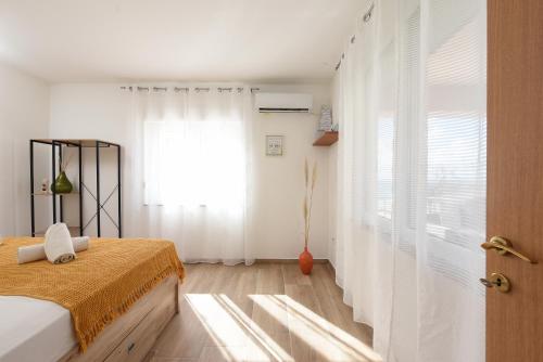 a bedroom with a bed and a window at Sunset Beach Suites in Kožino