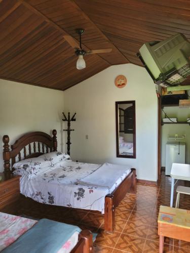 1 dormitorio con 2 camas y techo de madera en Pousada Mirante Santo Antônio, en Rio Prêto