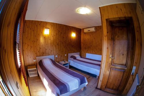 twee bedden in een kamer met houten wanden bij PENSIUNEA ETAP in Arad