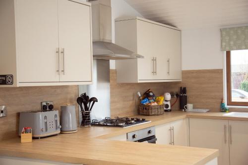 a kitchen with white cabinets and a counter top at 3 Bedroom lodge with hot tub in York