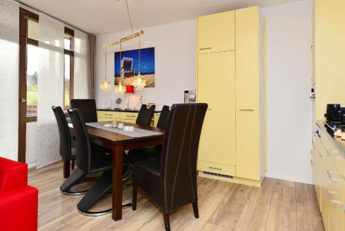 uma sala de jantar com uma mesa de madeira e cadeiras pretas em Ferienwohnung Appartement Seestern em Schluchsee